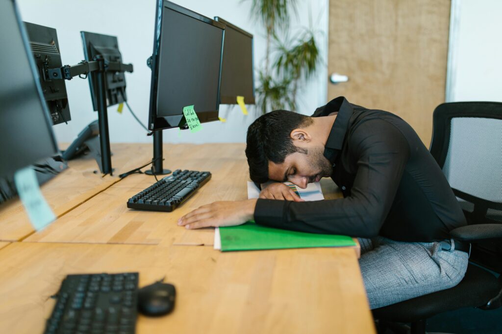 exhausted employee with head on desk
