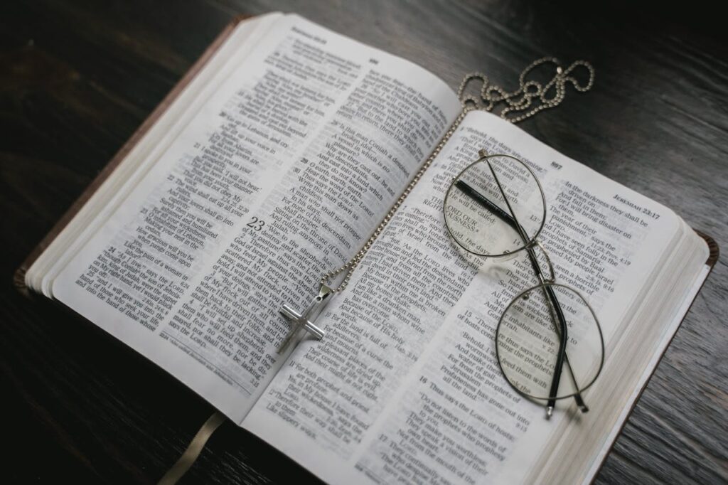 open bible with cross and eyeglasses