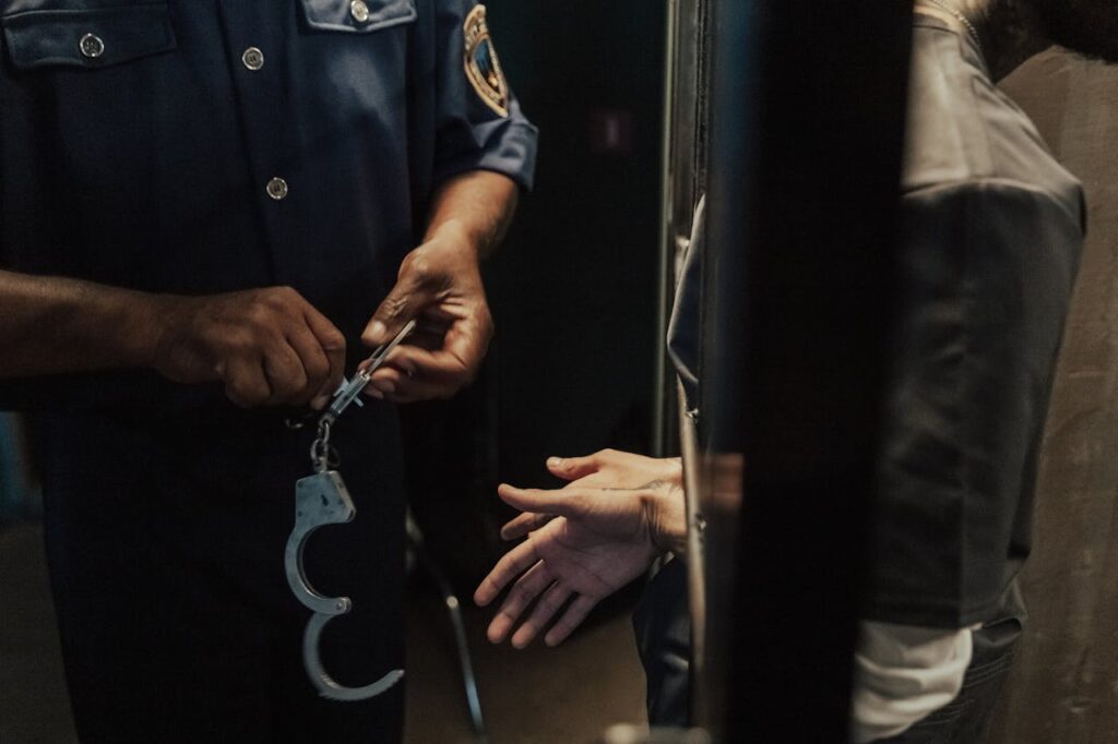 police officer with handcuffs and inmate behind bars